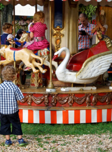 Historisches Karussell mit vielen Kindern und Eltern und Großeltern rundrum | © Anton Scherüble, Photogilde Aventin eV